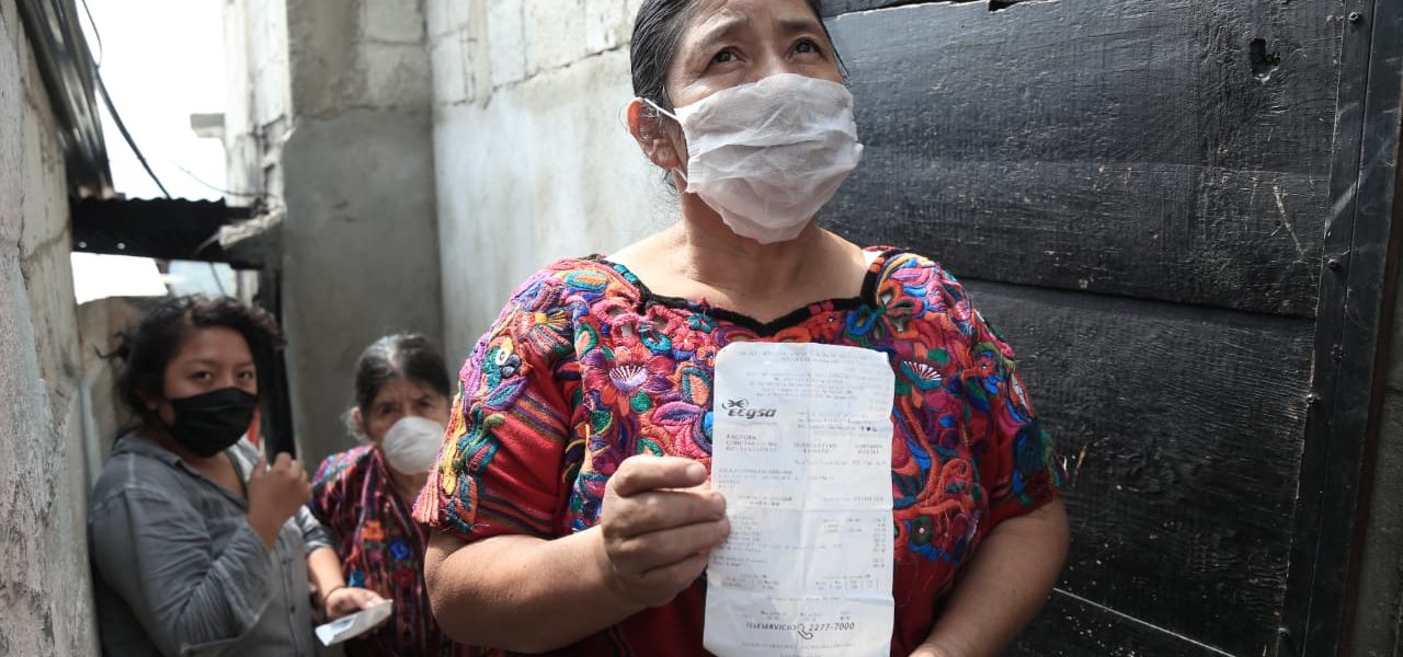 indígena guatemalteca recibe su recibo de luz marcado con el bono familiar