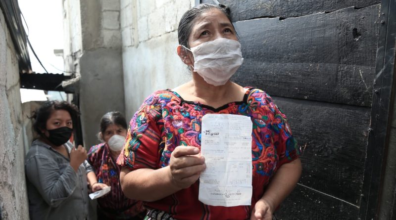 indígena guatemalteca recibe su recibo de luz marcado con el bono familiar
