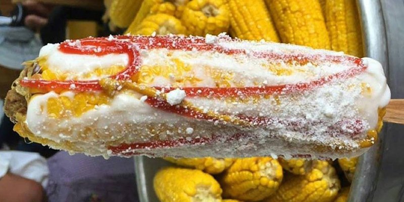 Delicioso plato típico de Guatemala, elotes locos son elotes hervidos con mayonesa, salsa de tomate y mostaza