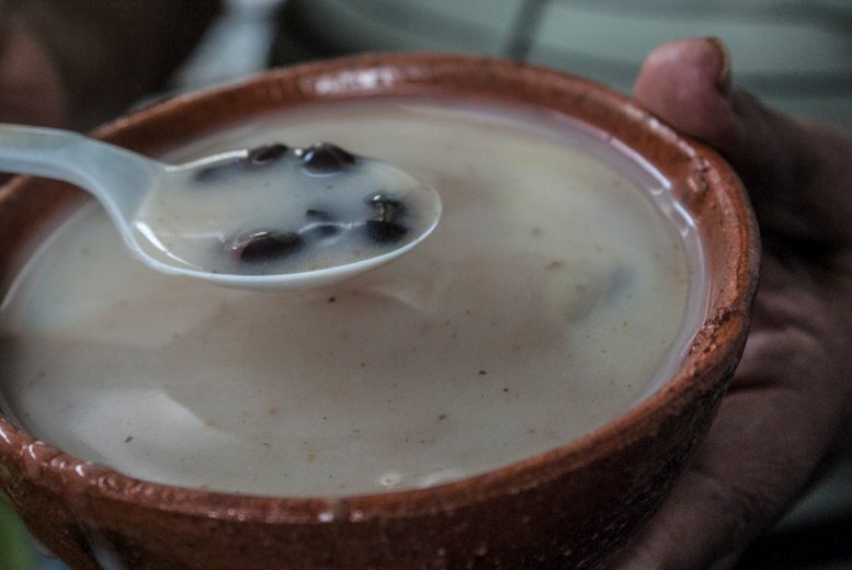 Receta de Atol Blanco Guatemalteco 1 Delicioso atol blanco guatemalteco servido en una escudilla de barro,, se puede observar una cucharada de atol con frijoles negros.