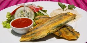 Plato de la gastronomia guatemalteca, contiene ejotes envueltos, ensalada verde, arroz, salsa roja,