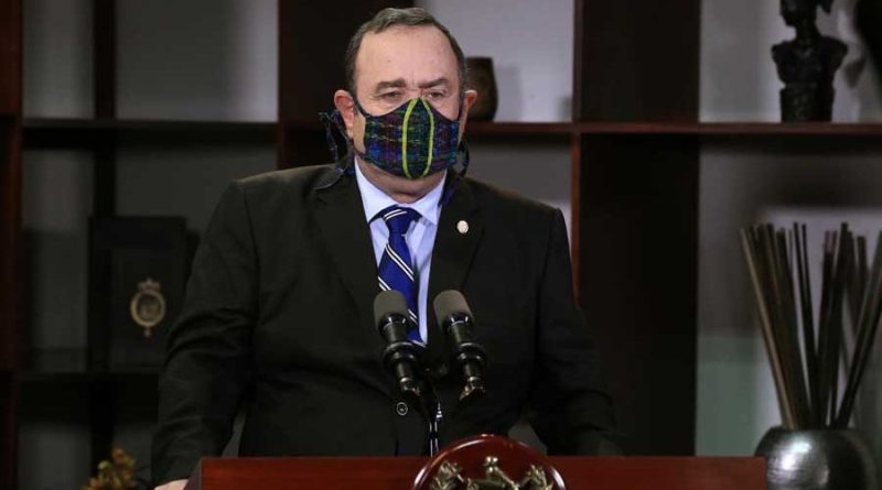 Presidente de Guatemala Alejandro Giammattei, con saco negro y mascarilla negra, dando declaraciones en cadena nacional