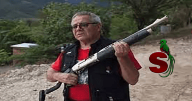 Peligroso terrorista guatemalteco Cesar Montes sosteniendo una escopeta con una playera roja