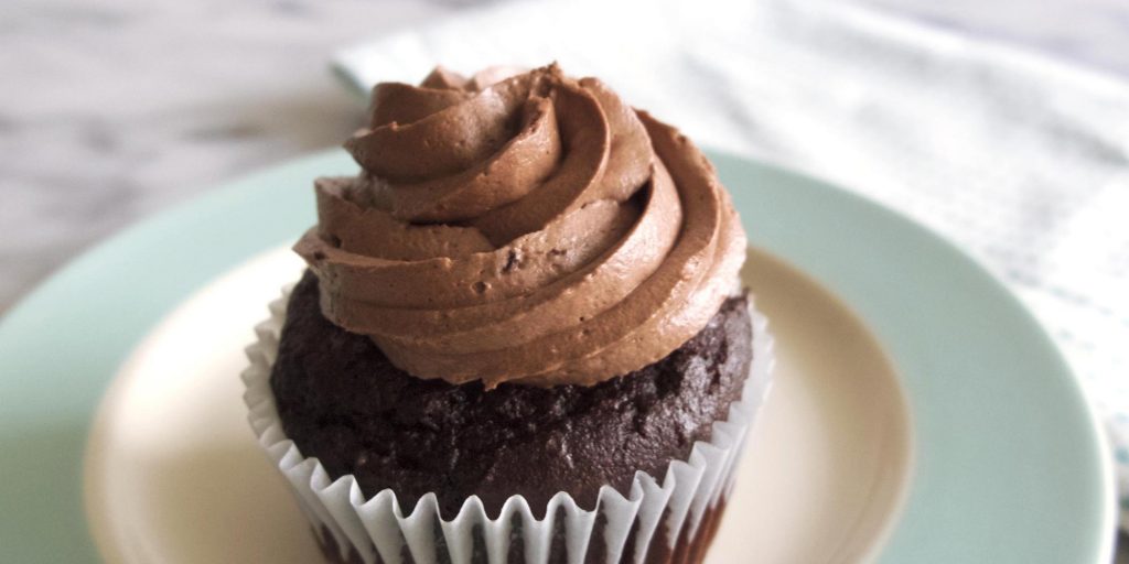 Un delicioso cupcake de chocolate esponjoso con betún arriba. 