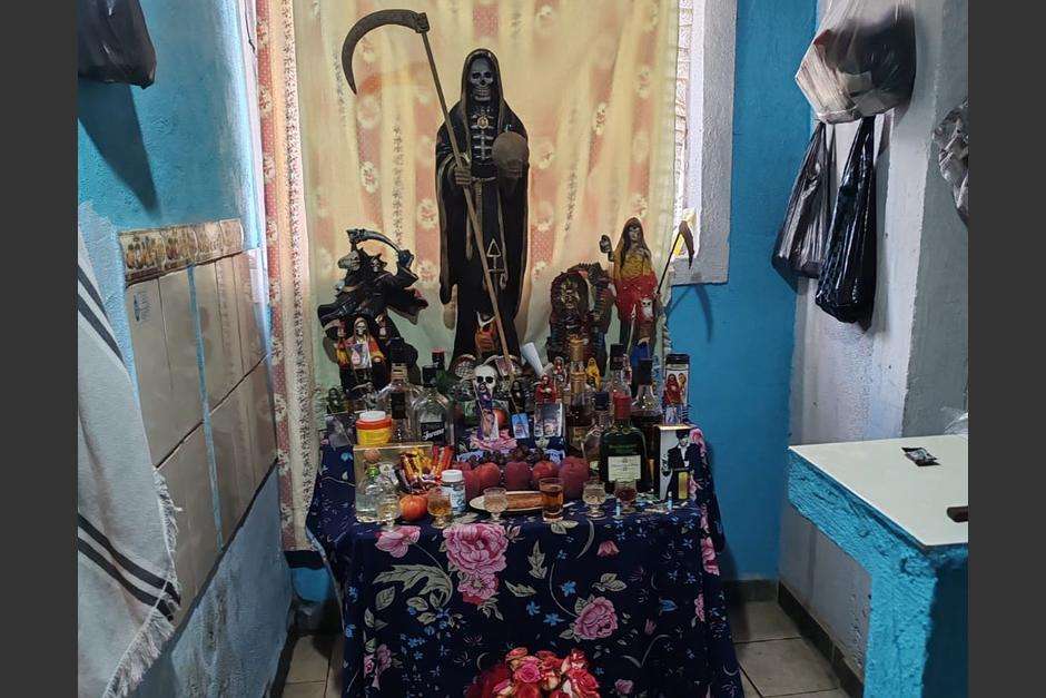 Un altar negro en honor a la Santa muerte con licores y drogas.