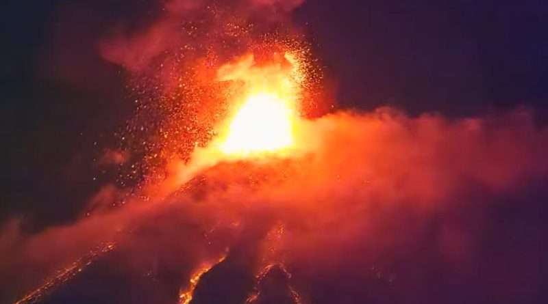 El Volcán de Fuego haciendo erupción, lava anaranjada se desliza por sus costados.