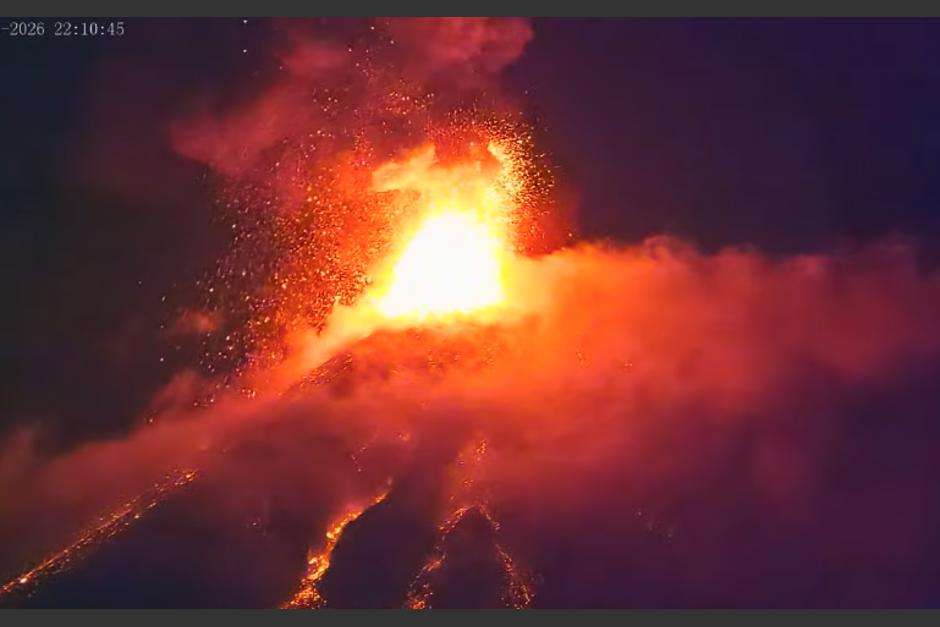 El Volcán de Fuego haciendo erupción, lava anaranjada se desliza por sus costados.